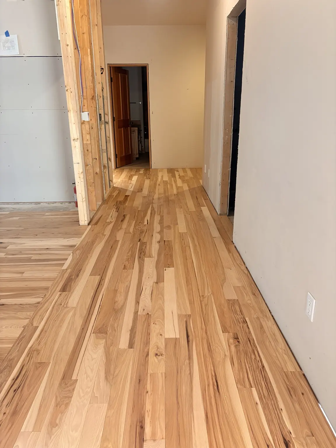 Natural hardwood flooring installed through a hallway